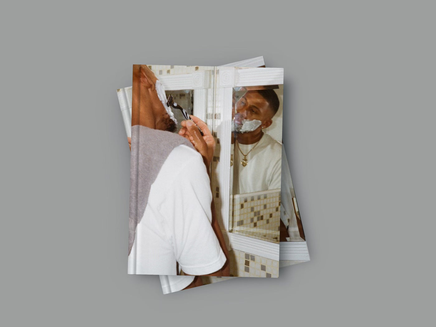 A photography book with a reflective cover showing a photograph of a man taking a picture of another man with a camera.